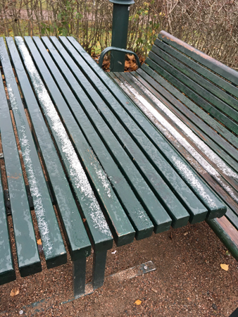 Snö på bord och bänk i Höganäsparken
