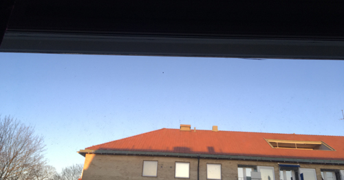 Ljusblå himmel över hustaken