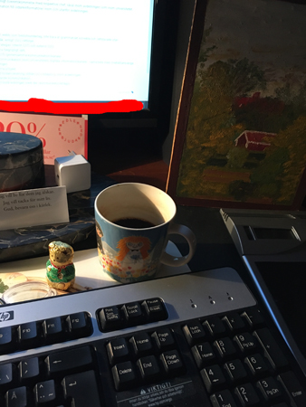 Fika med chokladnalle vid datorn