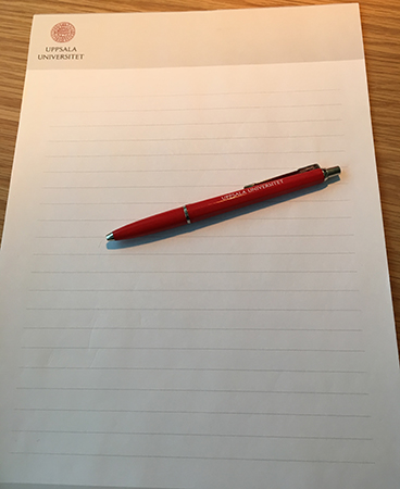 Block och penna med universitetets logga