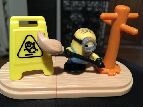 Minionleksak som sopar en skylt