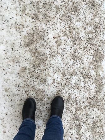 Mina fötter och ben på sandad trottoar