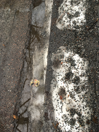 Snö och sand i trottoarkanten