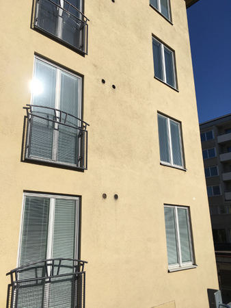 Hus med sol som speglar sig i ett fönster