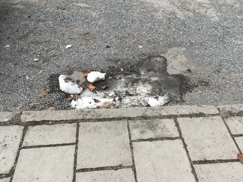 En snöfläck vid trottoarkanten