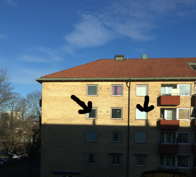 Två personers skugga på huset mittemot