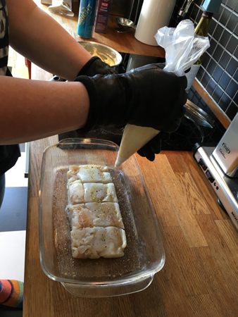 Anna spritsar mos med handskar på händerna