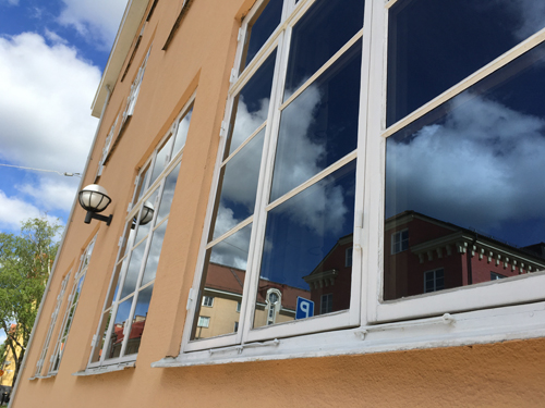 Hus som speglar sig i fönster Salagatan