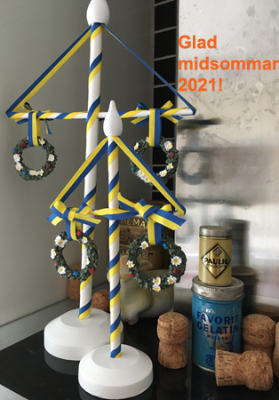 Glad midsommar 2021 och två vita midsommarstänger i trä med blågula band