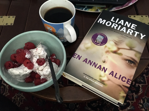 Glass med hallon kaffe o boken En annan Alice