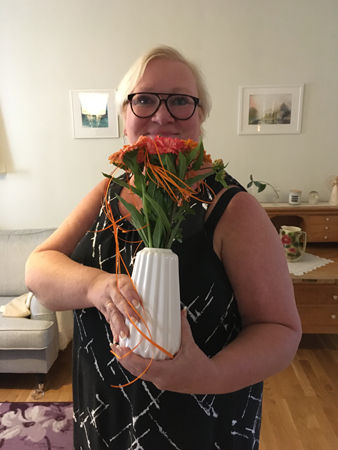 Inna med orange blommor i vas