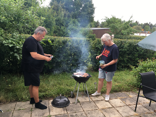Gymnasistens föräldrar samarbetar vid grillen