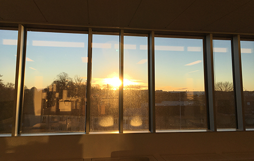 Solen går upp bakom husen