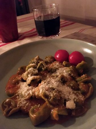 Fylld färsk pasta med tomatsås och ett glas Johanna