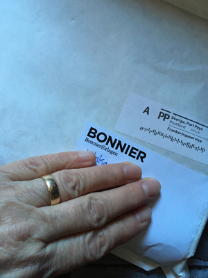 Vitt kuvert från Bonniers eg Forum med min hand på