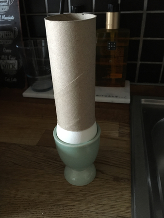 Toapappersrulle på kokt ägg i äggkopp