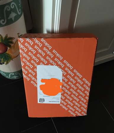 Bokpaket lutat mot paraplystället