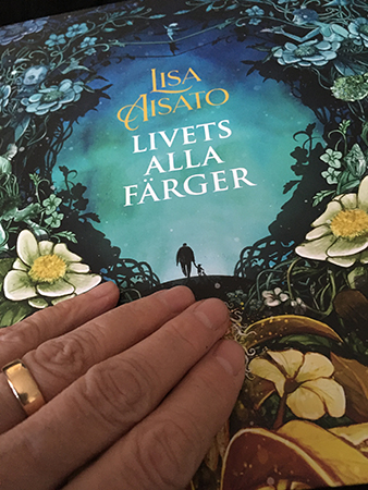 Min hand på boken Livets alla färger