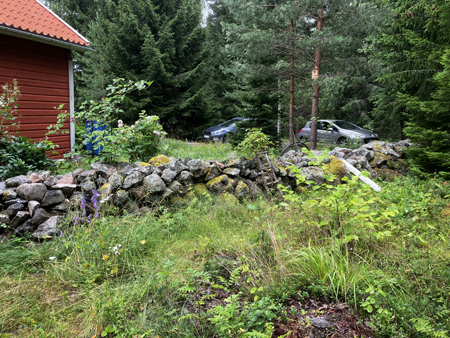 Bilarna parkerade på andra sidan muren