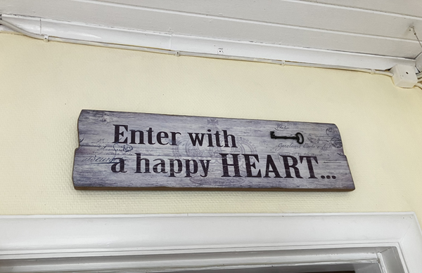 Skylt Enter with a happy heart