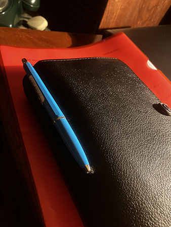 Filofax och protokoll i röd plastficka