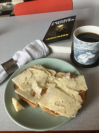 Rostade mackor kaffe linneservett med silverring o boken Grävlingen