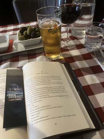 Öl uppslagen bok och oliver