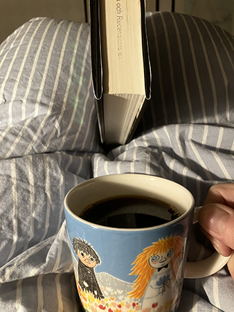 Bok och kaffe på sängen