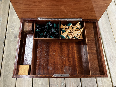 Inuti spelbordet pjäser och speldosa Helping Hand