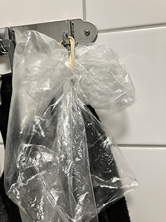 Plastpåse och gummisnodd till bandagerade handen