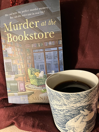 Söndagsmorgon med boken Murder at the bookstore och kaffe på sängen