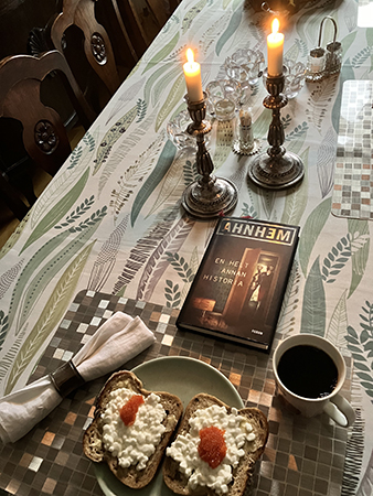 Kvällsmat med tända ljus och boken En helt annan historia