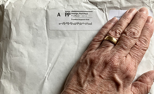 Min hand på ett vitt paket