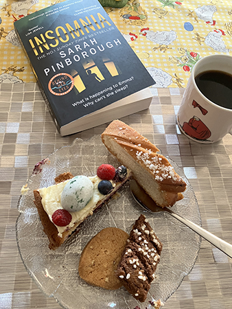 Kaffe tårtbit kardemummaskiva kakor och boken Insomnia