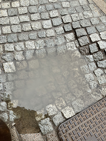 Vattenpöl på kullerstenar Vattenpöl på kullerstenar