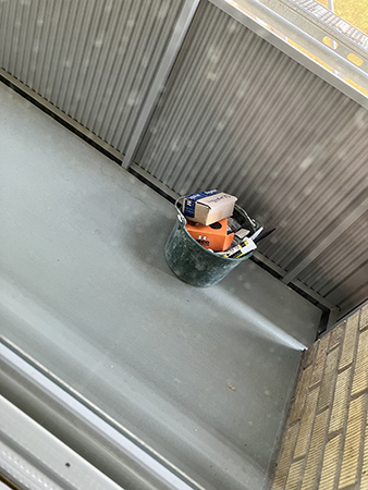 En hink med grejor på balkongen
