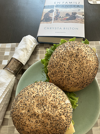 Två frallor med vallmofrön och boken En familj som andra