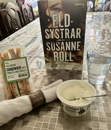 Hemmalunch med sandwich päronkvarg vatten o boken Eldsystrar