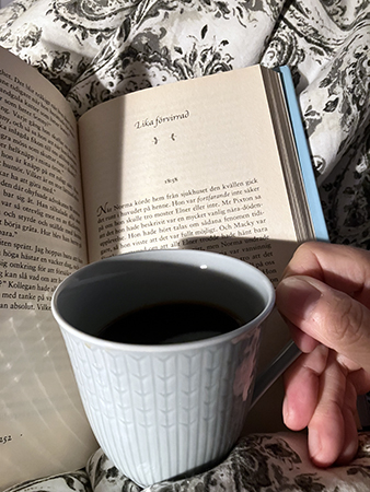 Bok med kapitelrubrik Lika förvirrad och kaffe på sängen