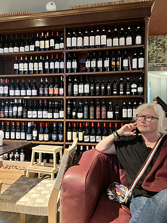 Anna väntar på vin hos Vinfolket