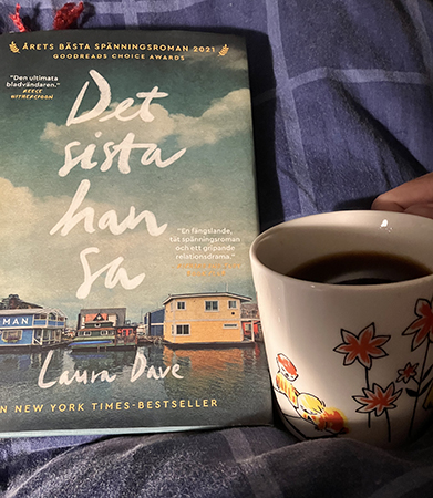 Läser boken Det sista han sa och dricker kaffe på sängen