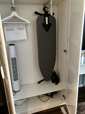 Garderob med golvfläkt och strykbräda hotellet