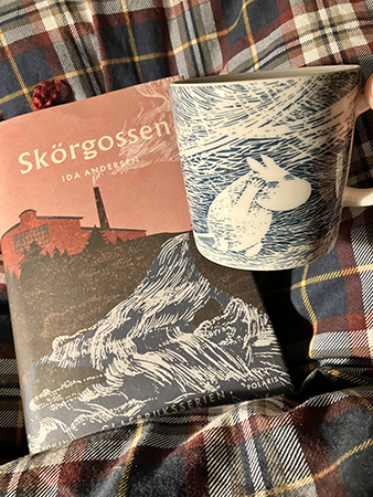 Boken Skörgossen och Muminmugg på sängen