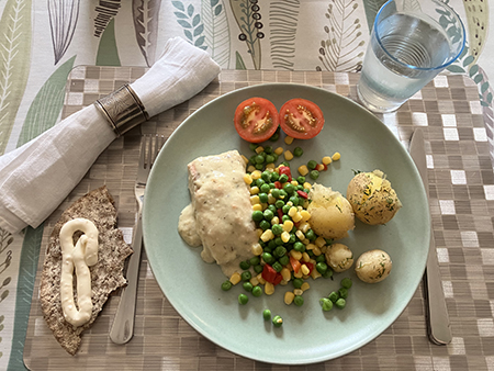 Laxmiddag med grönsaker och potatis knäcke och vatten