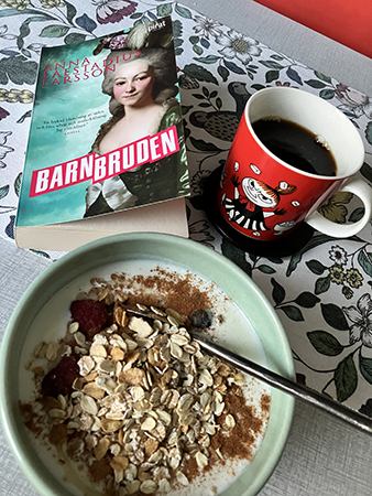 Torsdagsfrukostbordet med fil kaffe i lilla Mymugg o boken Barnbruden