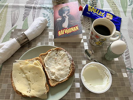 Hemmalunch med mackor kvarg kokt ägg kaffe o boken Räfvhonan