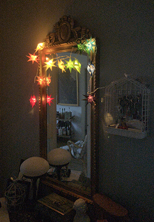 Lysande pappersstjärnor runt hallspegeln