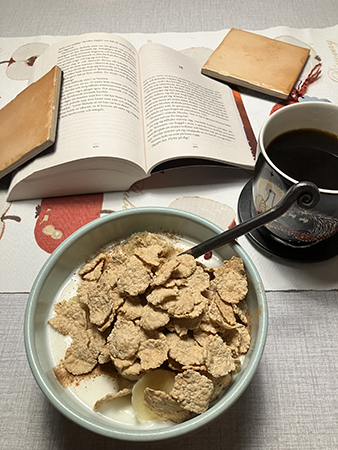 Vardagsfrukost med bok vid köksbordet