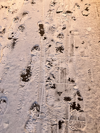 Fotspår i snön på trottoaren