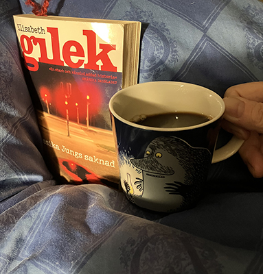 Boken Jessika Jungs saknad och kaffe på sängen i Förfadernmuggen